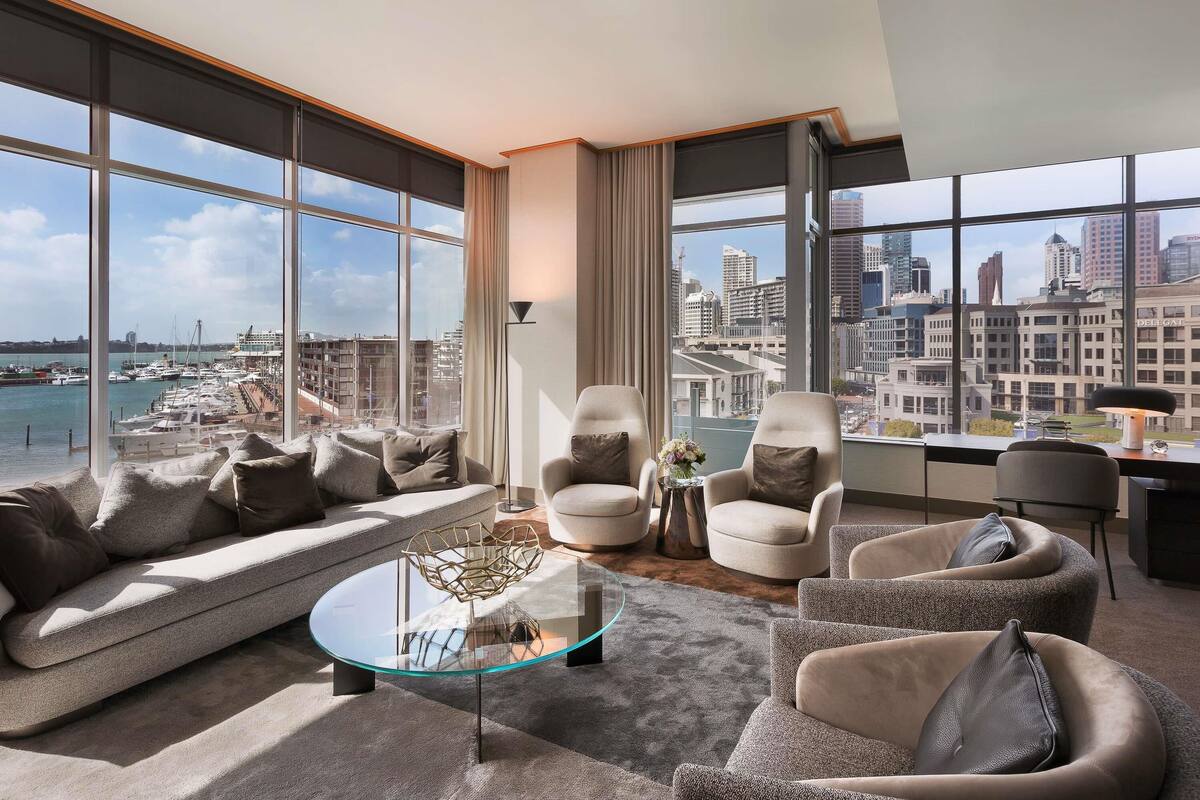 A modern living room with a large window, a glass coffee table, and a sofa.