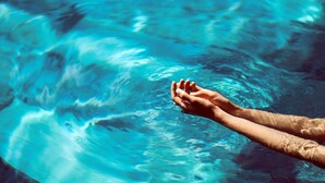A person's arms extended over a pool with clear water. - Sofitel Auckland Viaduct Harbour (Auckland)