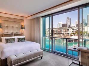 A hotel room with a large bed, a view of a cityscape, and a balcony with a pool. - Sofitel Auckland Viaduct Harbour (Auckland)