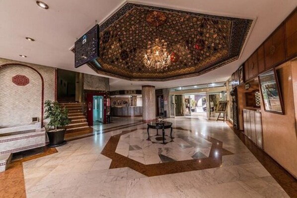 A spacious lobby with a high ceiling, a chandelier, and a star-patterned floor. - Menzeh Zalagh (Fes)