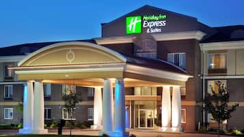 A Holiday Inn Express & Suites hotel with a covered entrance and a brick facade.