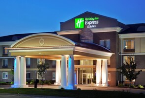 A Holiday Inn Express & Suites hotel with a covered entrance and a brick facade.