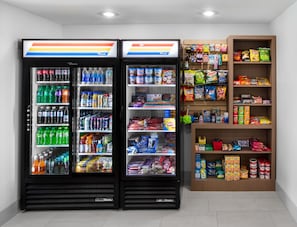 A vending machine stocked with various beverages and snacks, including sodas, juices, and chips.