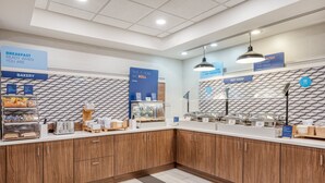 A clean, modern breakfast area with a bakery section, a hot food station, and a sign indicating breakfast is ready when you are. - Holiday Inn Express & Suites Vandalia by IHG (Vandalia)