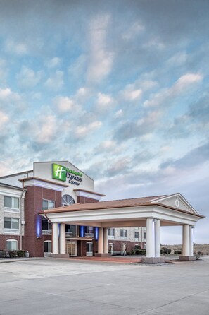 A Holiday Inn Express & Suites hotel with a brick facade and a covered entrance.