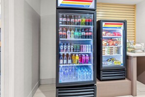 Two beverage dispensers with Coca-Cola and Sprite, and a snack display. - Holiday Inn Express & Suites Vandalia by IHG (Vandalia)