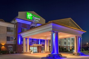 A Holiday Inn Express & Suites hotel with a covered entrance and illuminated columns. - Holiday Inn Express & Suites Vandalia by IHG (Vandalia)
