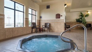 A hot tub with a metal railing, a tiled floor, and a view of the outside through large windows. - Comfort Inn & Suites Goodland (Goodland)