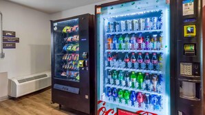Two vending machines stocked with snacks and beverages, including Coca-Cola. - Extended Stay America Select Suites - Fayetteville (Fayetteville)
