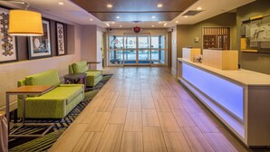 A hotel lobby with a reception desk, seating area with sofas, and a patterned carpet. - Holiday Inn Express and Suites Modesto by IHG (Modesto)