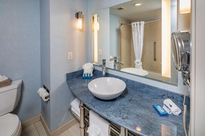 A bathroom with a white sink, a large mirror, and a shower curtain.