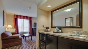 A hotel room with a sofa, a dining table, a kitchen area with a microwave, refrigerator, and sink. - Hampton Inn & Suites Las Cruces I-25 (Las Cruces)