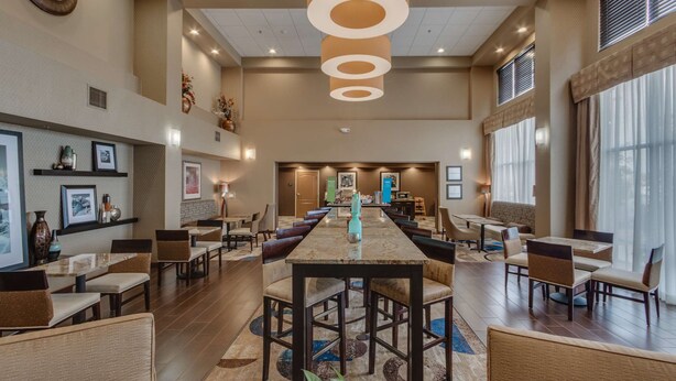 A spacious hotel lobby with a long reception desk, multiple seating areas, and large windows allowing natural light. - Hampton Inn & Suites Las Cruces I-25 (Las Cruces)