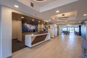 A modern reception area with a reception desk, seating area, and large windows.