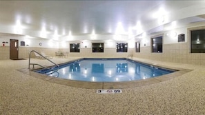 An indoor swimming pool with a tiled floor, a pool ladder, and a depth marker indicating 3 feet 9 inches.