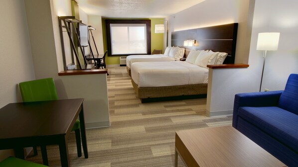 A hotel room with a bed, a desk, a chair, and a sofa.