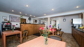 A restaurant with wooden furniture, a wooden counter, and a refrigerator.