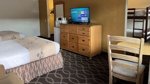 A hotel room with two beds, a wooden dresser, a television, and a chair.