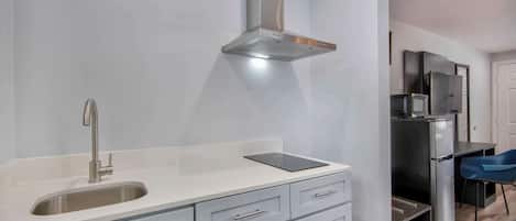 Een koelkast met diepvriezer, een microgolfoven, een kookplaat