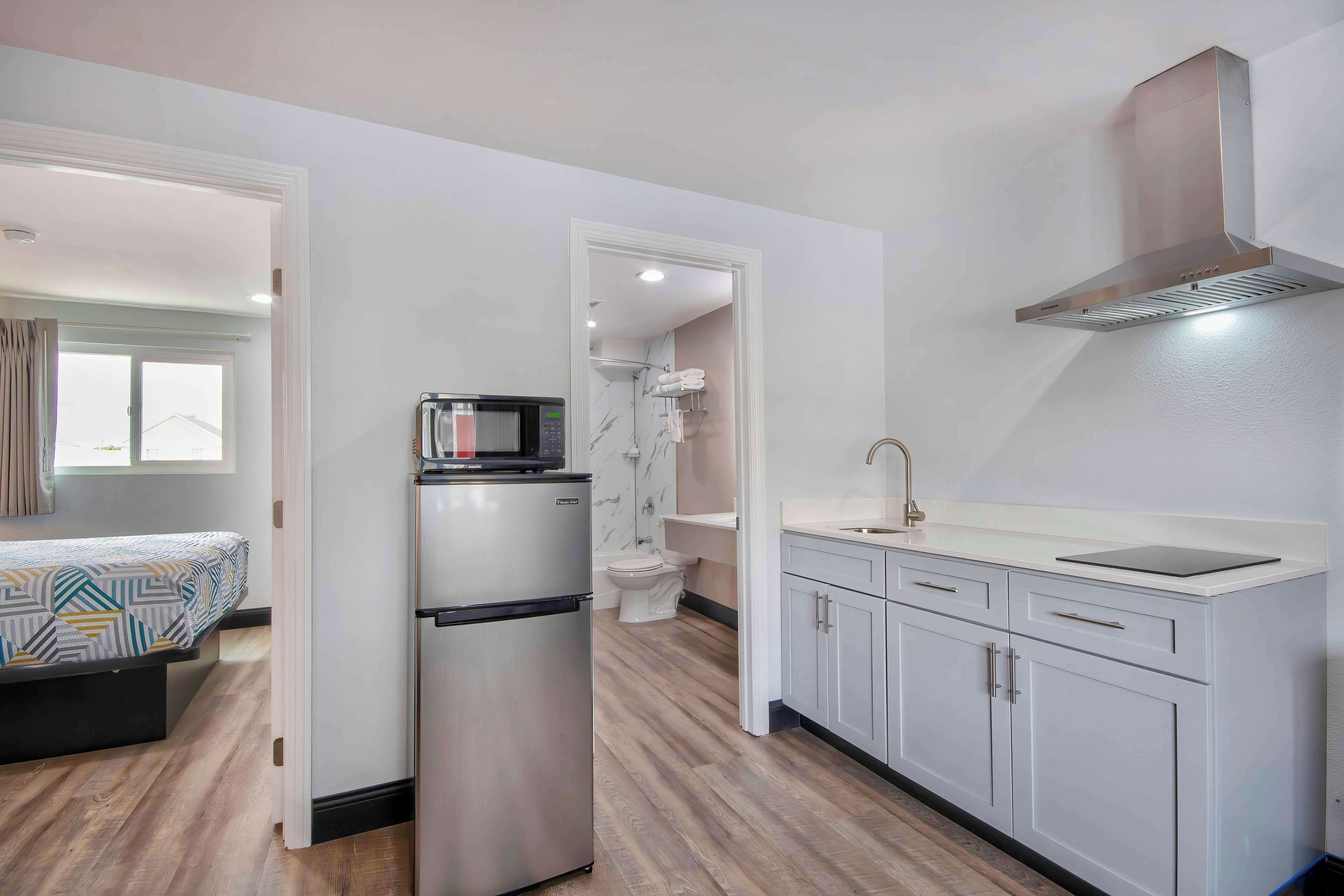 A compact kitchen with a refrigerator, microwave, and sink.
