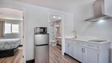 A compact kitchen with a refrigerator, microwave, and sink.