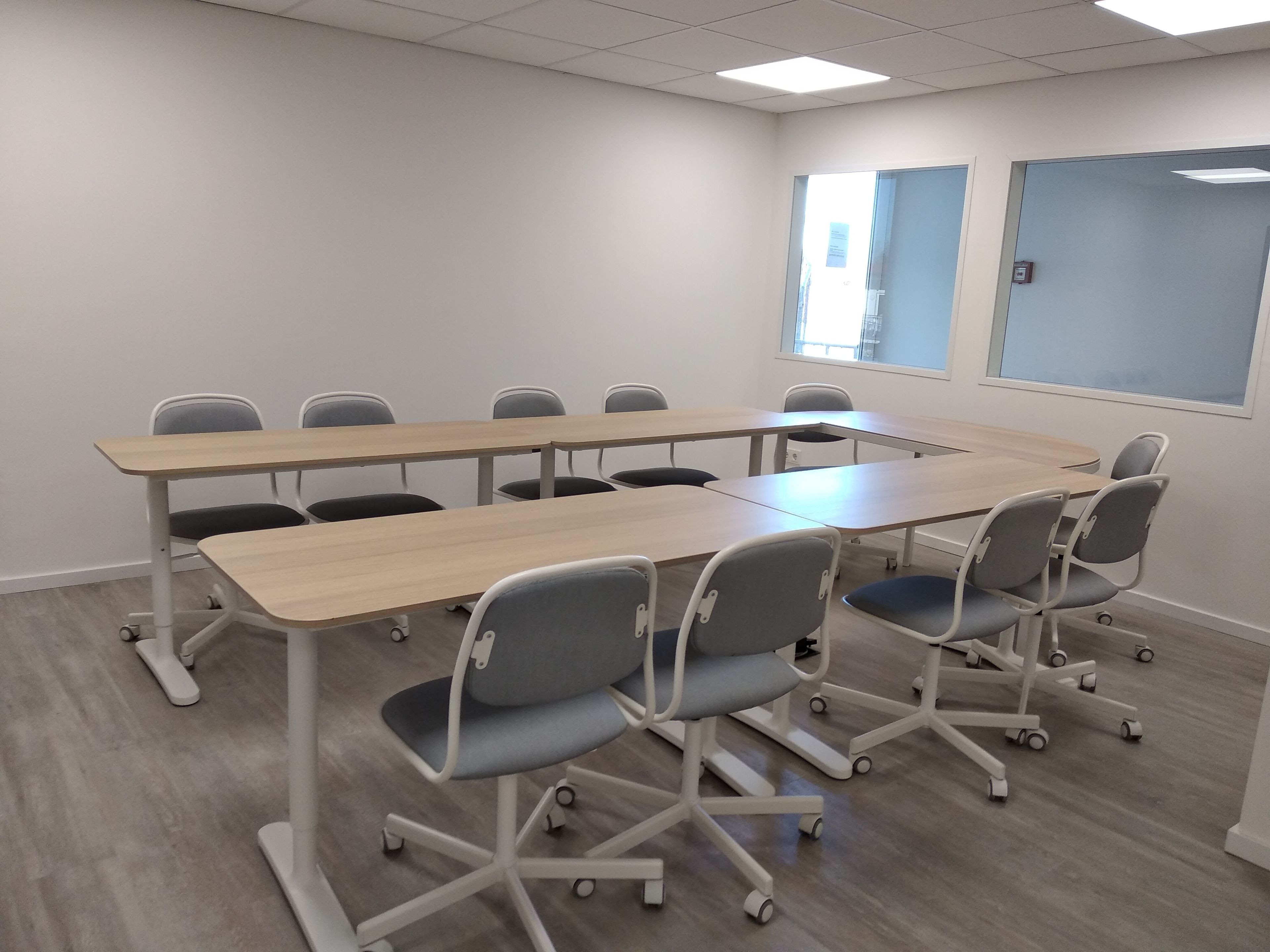 Una sala de conferències amb una taula llarga i sis cadires.