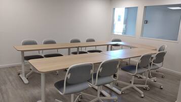 Una sala de conferències amb una taula llarga i sis cadires.
