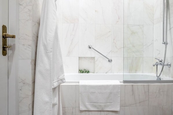 A bathroom with a bathtub, a shower, and a glass-enclosed shower area.