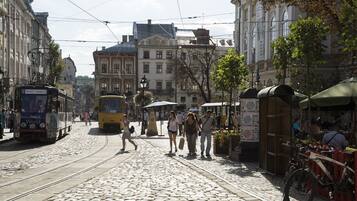 Une rue pavée avec des rails de tramway, des bâtiments historiques et un tramway en mouvement.
