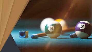 A pool table with billiard balls and cues.