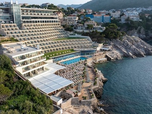 Un hotel frente al mar con varios balcones, piscina y vistas al océano.