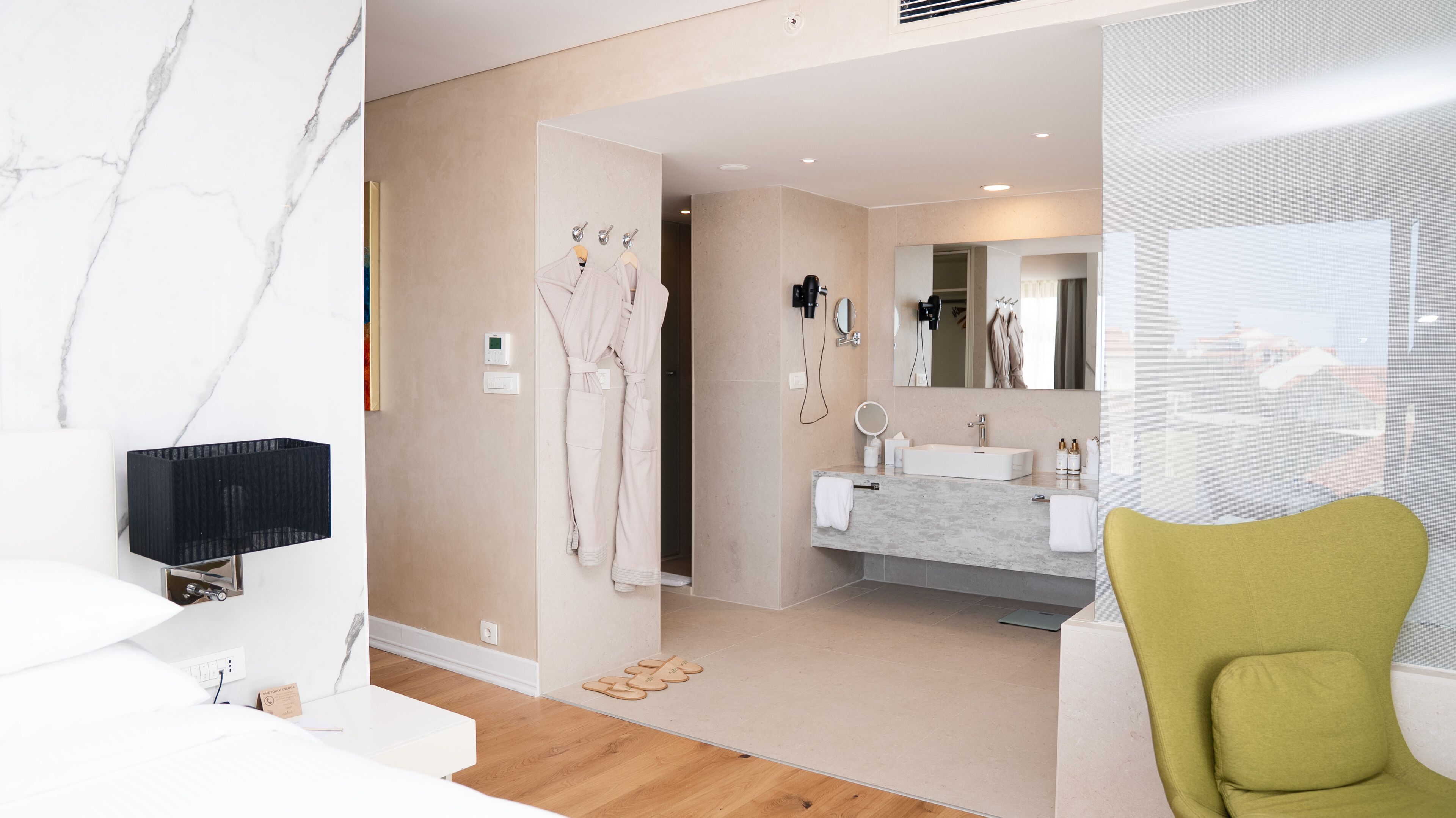 A modern bathroom with a vanity, mirror, and towel rack.