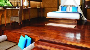 A room with a high, sloped ceiling, a bed with a canopy, a desk with a lamp, and a chair. - Jetwing Vil Uyana, A Luxury Reserve (Sigiriya)