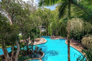 A large, clear swimming pool surrounded by lush greenery and palm trees. - Drift Palm Cove (Palm Cove)