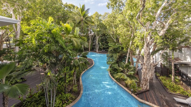 A swimming pool surrounded by lush greenery and trees. - Drift Palm Cove (Palm Cove)