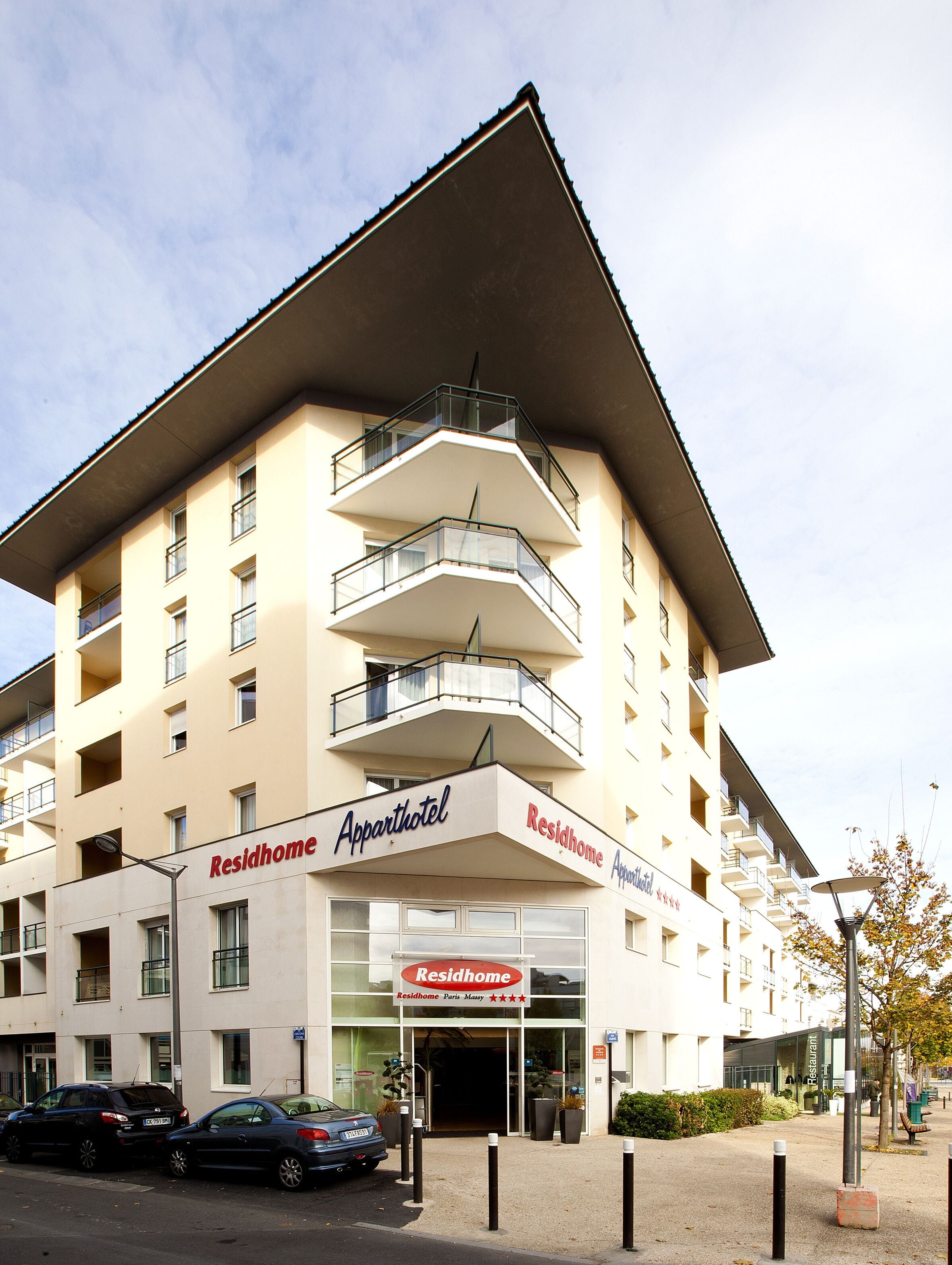 Ein mehrstöckiges Gebäude mit Balkonen, mit der Aufschrift "Apparthotel" und "Residhome".