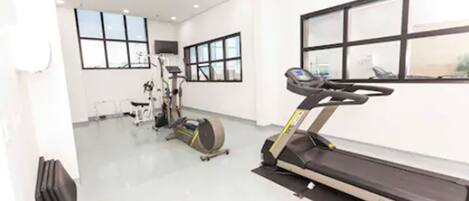 A gym with treadmills, stationary bikes, and other fitness equipment.