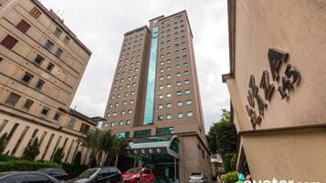 A tall hotel building with a modern design, featuring a prominent glass facade and multiple floors.