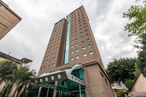 Un edificio alto y moderno con fachada de vidrio y una estructura de entrada curva distintiva.