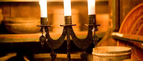 Um candelabro com três velas acesas em um ambiente rústico.
