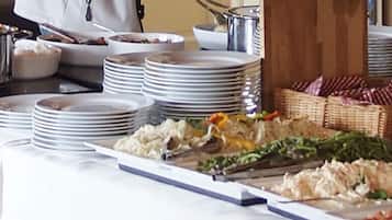 A buffet setup with various dishes and stacked plates.