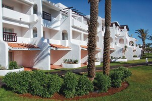 Un bâtiment blanc doté de balcons et surmonté d’un toit en tuiles.