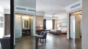 A modern hotel room with a large bed, a sitting area with a chair, a desk, and a large mirror. - Hotel Riu Tikida Dunas - All Inclusive (Agadir)