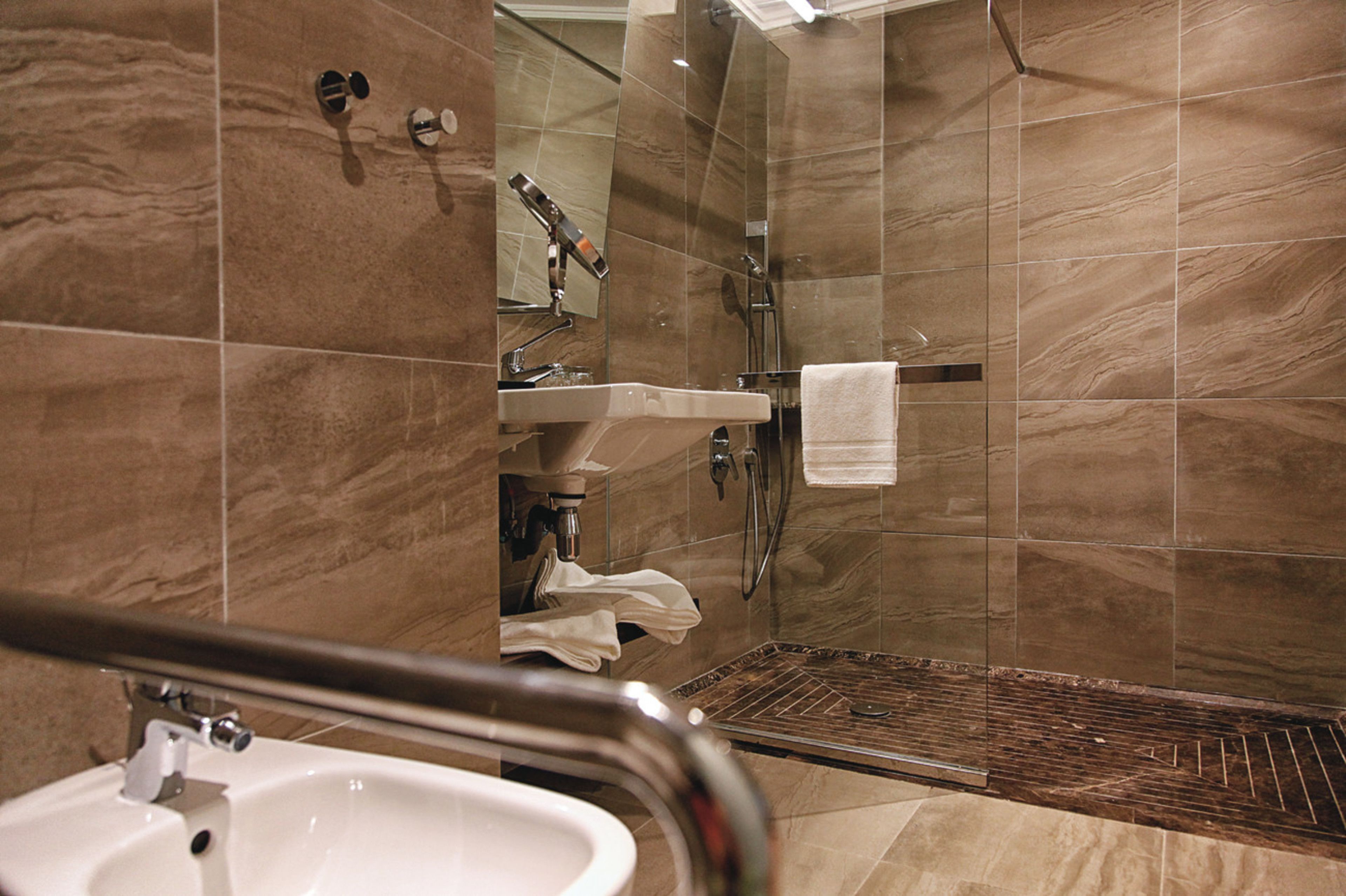A modern bathroom with a sink, mirror, and shower.