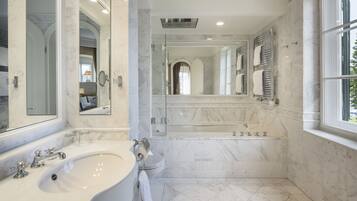 Ein modernes Badezimmer mit einer großen Badewanne, einer separaten Duschkabine und einem Waschtisch.