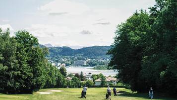 Ein Golfplatz mit Blick auf eine Stadt und Berge im Hintergrund.