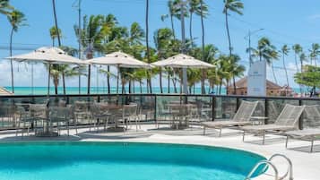 Una piscina al aire libre, camas de piscina gratis, sombrillas