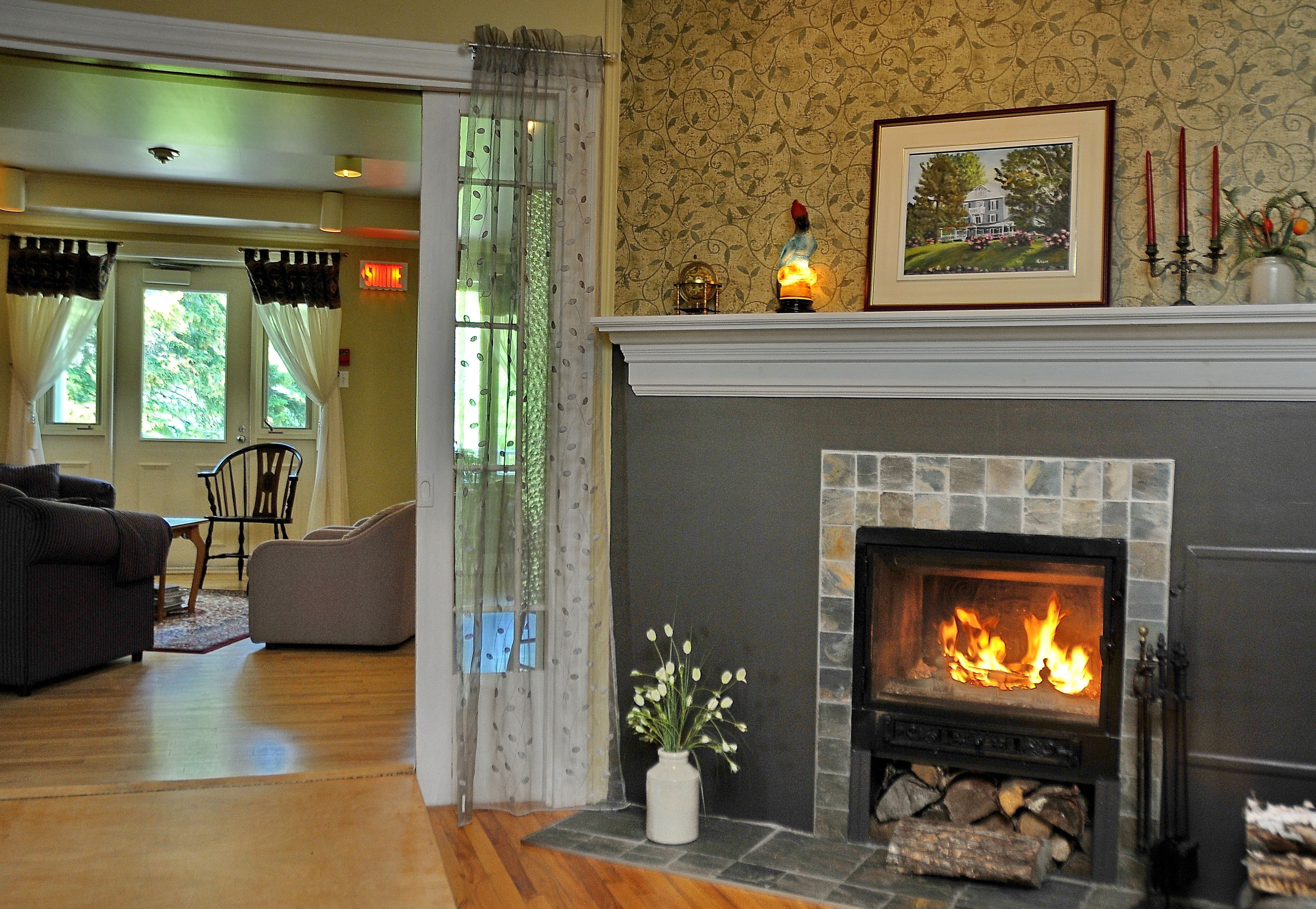 Una sala de estar con chimenea, un sofá, una silla y una mesa de comedor.