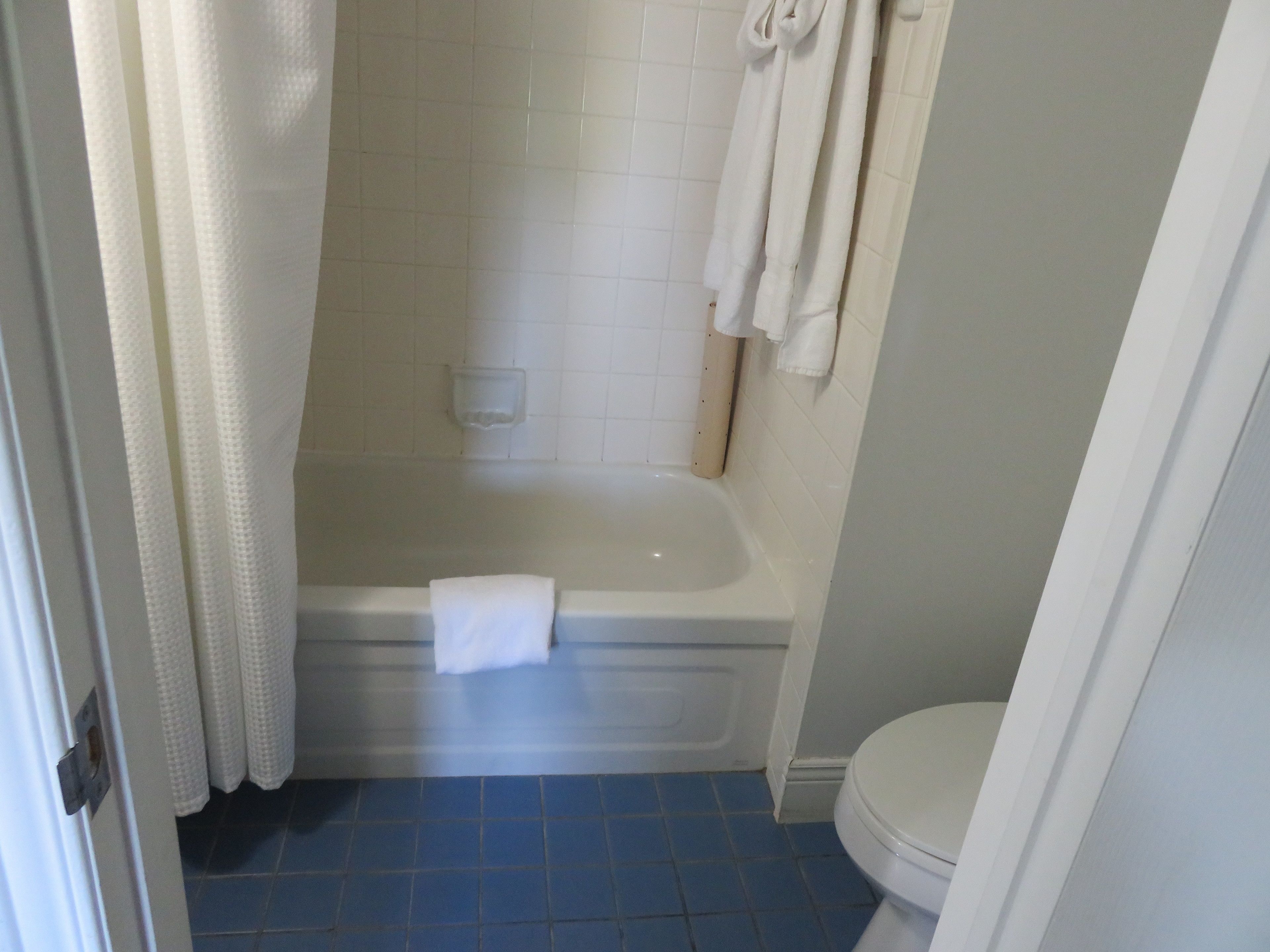 Un baño con bañera, inodoro y cortina de ducha.