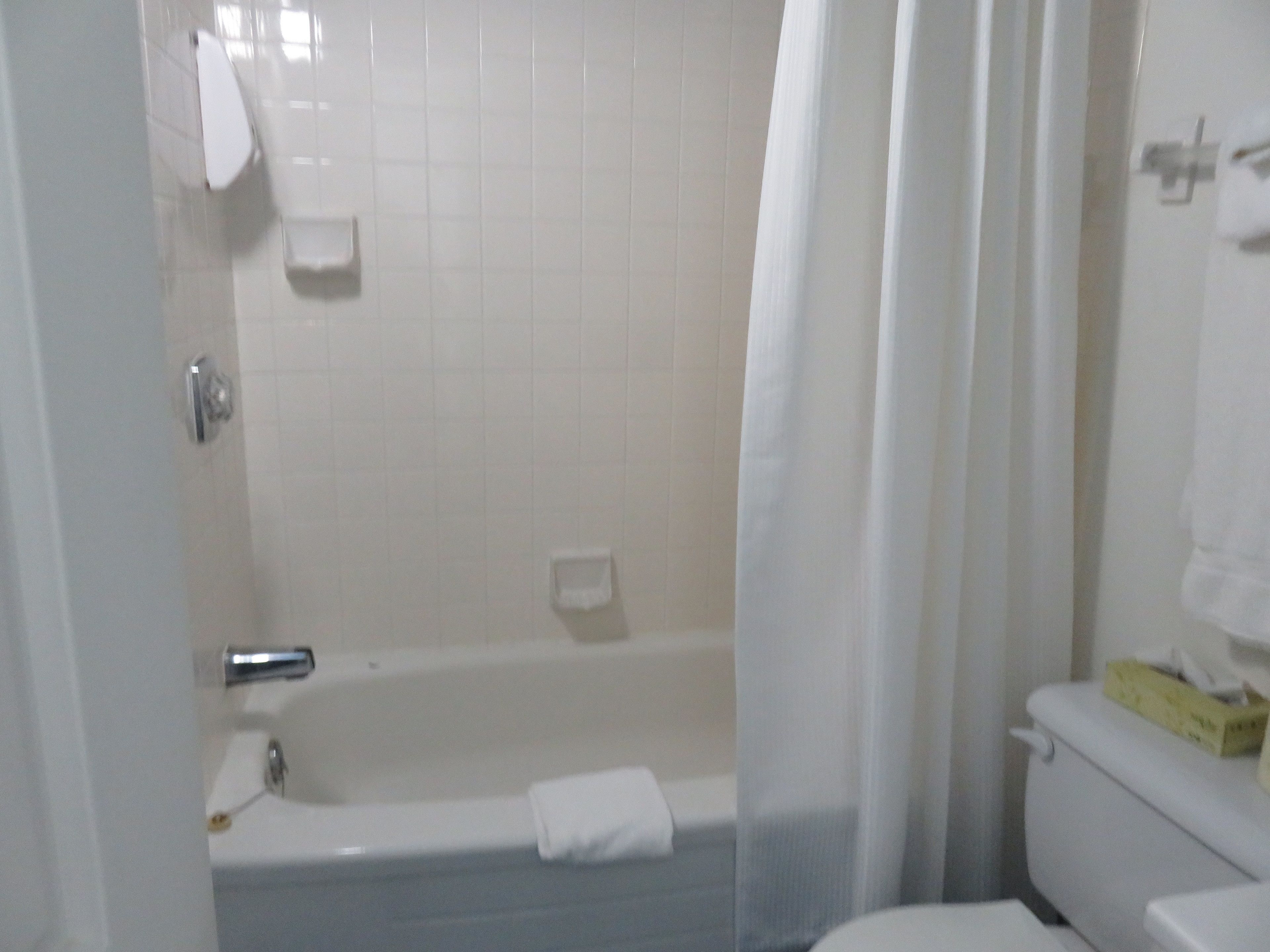 Une salle de bain avec une baignoire, des toilettes et un rideau de douche.